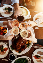 Wine, Food And Hands Of People Toast To Celebrate At Table For Holiday, Christmas Or Thanksgiving Dinner Party. Above Group Of Family Or Friends With Drinks For Cheers While Eating Lunch Or Dinner