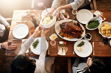 Wall Mural - Food, people and eating together at table for holiday celebration or dinner party. Above group of family or friends hands sharing healthy lunch with chicken or turkey, vegetables and wine drinks