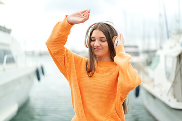 Sticker - Teenager girl at outdoors listening music and dancing