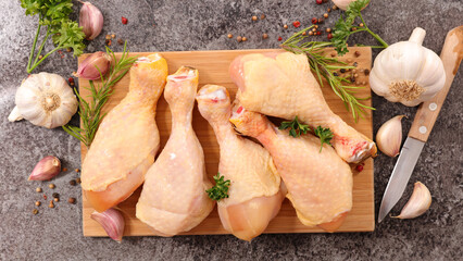 Wall Mural - raw chicken leg and spices on wooden cutting board