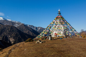 Wall Mural - Stupa with prayer flags in Haizi valley near Siguniang mountain in Sichuan province, China