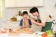 © tonefotografia - Happy Young Asian father and son cooking in kitchen at home