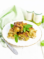 Canvas Print - Rolls of zucchini with meat in plate on wooden board