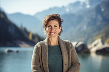 Wall Mural - Group portrait photography of a grinning woman in her 30s wearing a chic cardigan against a mountain lake or alpine background. Generative AI