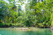 Cruising on the beautiful and calm river with trees at Kali Cokel, Pacitan, Indonesia.