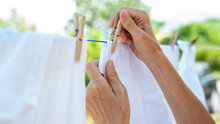 Woman Hands Hangs Laundry On Clothesline
