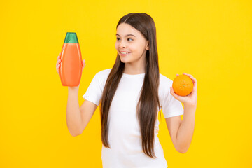 Canvas Print - Teenager child girl showing bottle shampoo conditioners or shower gel. Hair cosmetic product. Bottle for advertising mock up copy space. Happy teenager portrait. Smiling girl.