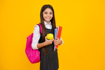 Wall Mural - Schoolchild, teenage student girl with school bag backpack hold aplle and books on yellow isolated studio background. Children school and education concept.