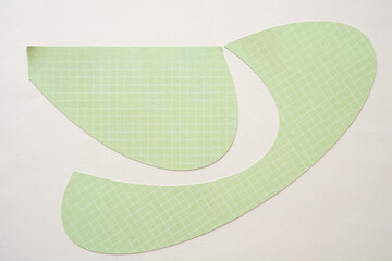 Sticker - stylized curve or crescent shapes cut from decorative scrapbook paper on blank beige paper background