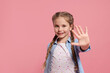 Cheerful girl giving high five on pink background, space for text