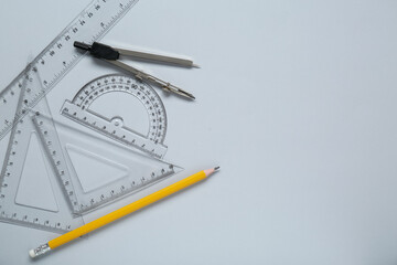 Different rulers and compass on light grey background, flat lay. Space for text