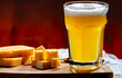 © barmalini - Glass of Belgian white unfiltered beer with notes of coriander and orange peer and wooden board with belgian cheese made by monks from cow milk