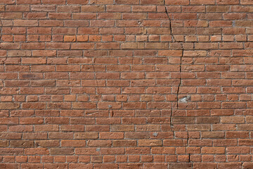 Canvas Print - Full frame texture background of an old reddish brown clay brick wall with a common bond brickwork pattern, showing major cracking in its structure