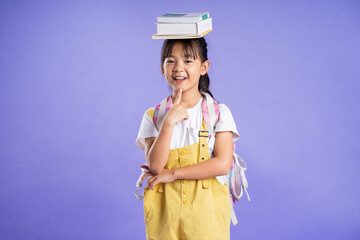 Wall Mural - cute asian schoolgirl posing on purple background