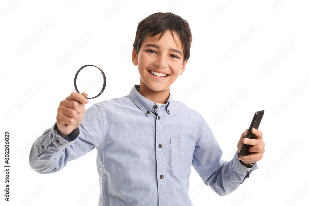 Little boy with magnifier and mobile phone on white background