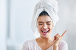Happy woman, head towel and cream on nose for cosmetics, beauty and dermatology. Female person, face and laughing with facial lotion after shower for healthy shine, glow or aesthetic skincare at home