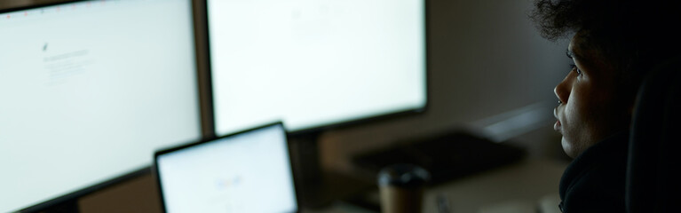 be busy. skilled specialist, guy sitting in front of many computer monitors, testing, finishing or d
