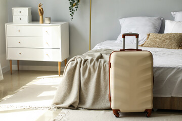 Poster - Big suitcase near bed in light room