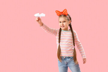 Poster - Little girl with paper plane on pink background. Children's Day celebration