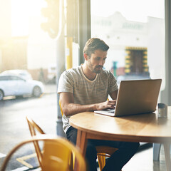 Coffee shop, typing and serious man with laptop and lens flare doing code work in a cafe. Tech, email and male freelancer customer at restaurant with online job and computer writing with focus