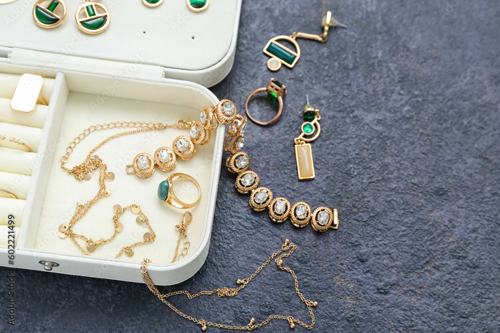 Organizer with stylish jewelry on grunge dark background