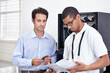 © Lionel Henshaw/peopleimages.com - Server room, it support and reading with an engineer working with a business man for cyber security. Network, database and instructions with a male technician doing research about installation