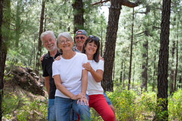 Sticker - Portrait of four smiling senior tourists in mountain park looking at camera - Group of happy retiree enjoying nature and trekking day together