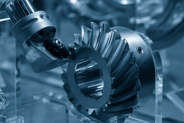 Wall Mural - Close up  the spiral bevel gear part and the lathe tool in the light blue scene.