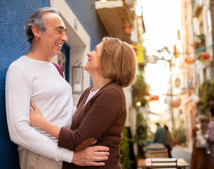 Wall Mural - Joyful Mature European Couple Hugging Standing Outside On A Street