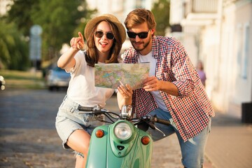 Young couple traveling, reading map in the city