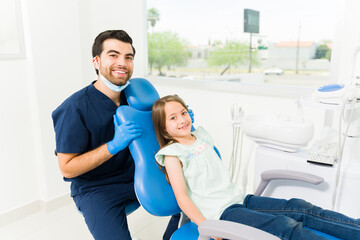 Wall Mural - Portrait of a male pediatric dentist and little kid looking happy