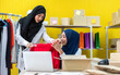 © Art_Photo - Muslim two asian woman freelancer sme business online shopping working and checklist order with cardboard box on table at home - Business online shipping and delivery concept