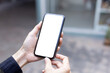 © panitan - cell phone blank white screen mockup.hand holding texting using mobile on desk at office.background empty space for advertise.work people contact marketing business,technology