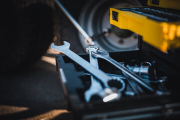 Wall Mural - Mechanical tools box. Worker using different repair tools for repairing and service. Tool set near the auto. Closeup. Automobile servicing and repair concept.