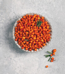 Poster - fresh ripe sea buckthorn in a gray plate on a light gray background top view