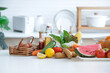 Assorted organic vegetables and fruits and eggs on table in bright white kitchen, healthy lifestyle concept