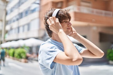 Poster - Young blond man listening to music at street