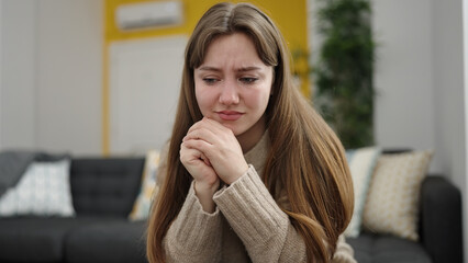 Sticker - Young blonde woman stressed sitting on sofa at home