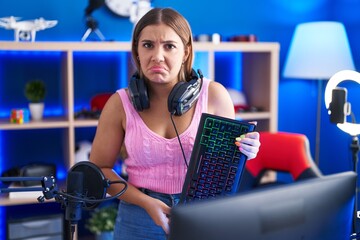 Sticker - Young blonde woman playing video games holding keyboard depressed and worry for distress, crying angry and afraid. sad expression.