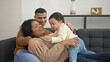 © Krakenimages.com - Couple and son hugging each other sitting on sofa at home