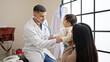 © Krakenimages.com - Couple and son examining baby with stethoscope at clinic