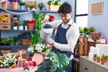 Sticker - Young hispanic man florist smiling confident watering flowers at florist shop