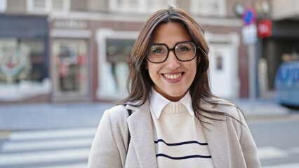 Wall Mural - Young beautiful hispanic woman smiling confident standing at street