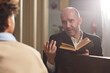 © Seventyfour - Mature pastor reading Bible and talking to boy during their meeting in church