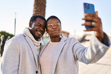 Canvas Print - Man and woman couple standing together make selfie by the smartphone at street