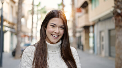 Wall Mural - Young beautiful hispanic woman smiling confident standing at street