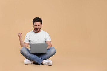 Poster - Emotional man with laptop on beige background. Space for text