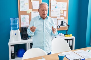 Wall Mural - Middle age grey-haired man business worker speaking at office