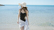 © Krakenimages.com - Young chinese woman tourist wearing swimsuit with relaxed expression walking at seaside