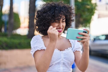 Sticker - Young middle east woman smiling confident using smartphone at park